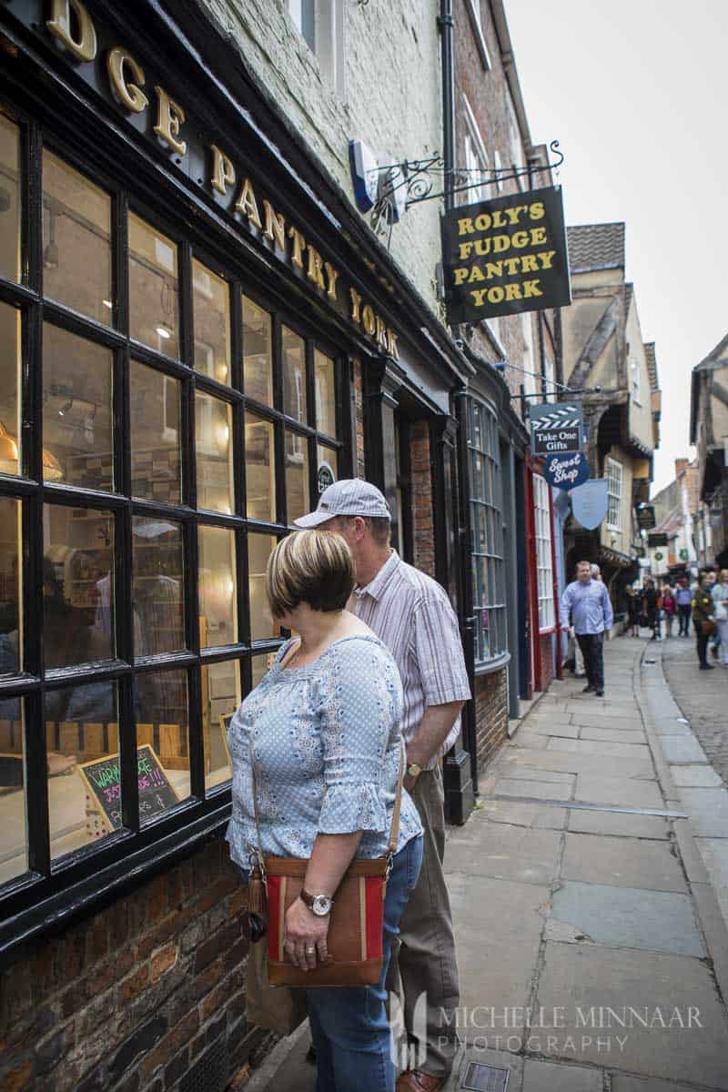 Two people looking into the window of the York Fudge location 