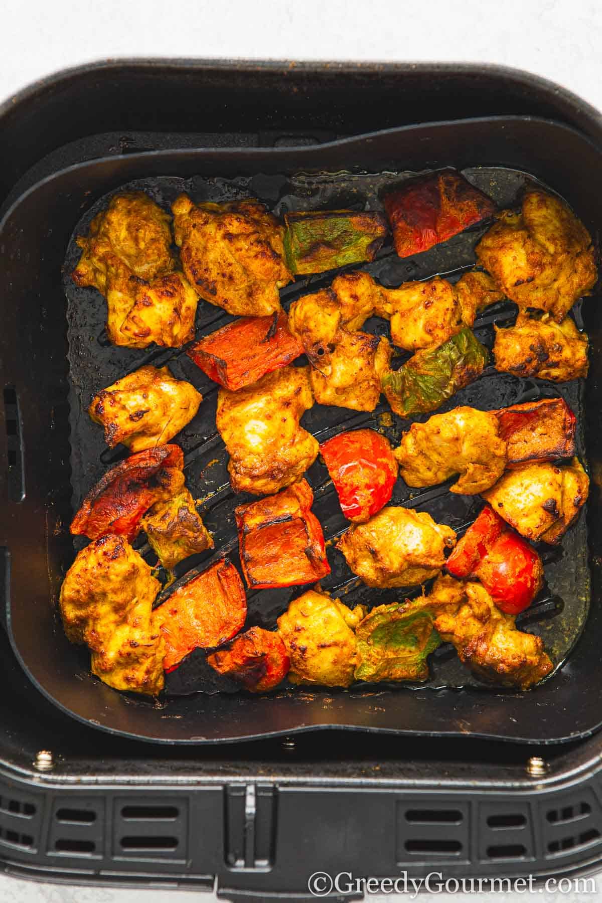 Air fryer chicken tikka in an air fryer pan.