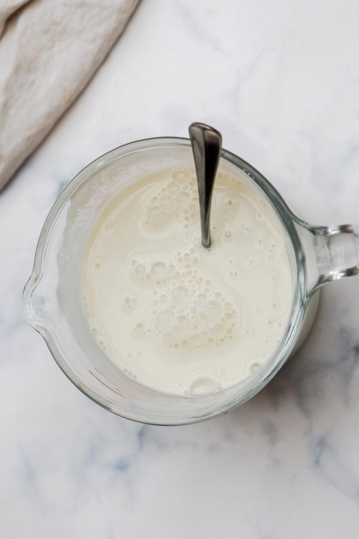 Milk, vanilla, and apple cider vinegar in a measuring jug.