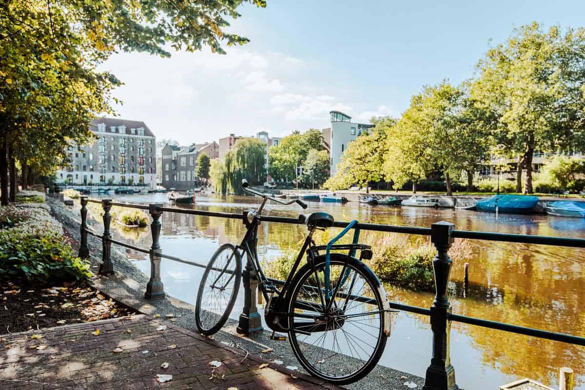 bicycle leaning against a rail next to a canal.