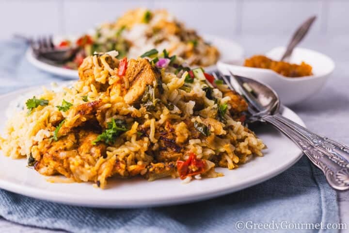 Chicken tikka biryani on a white plate.