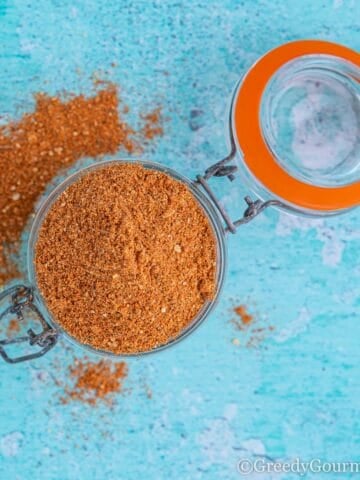 An open clear jar of cajun seasoning