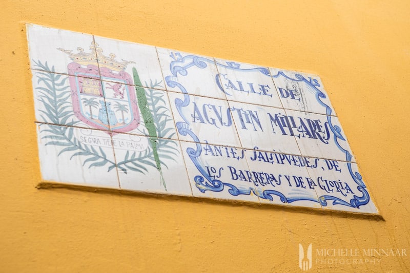 Blue and white tiles on a yellow wall