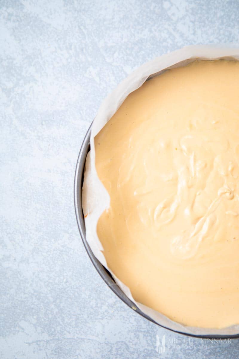 Cheesecake filling in tin lined with baking paper.