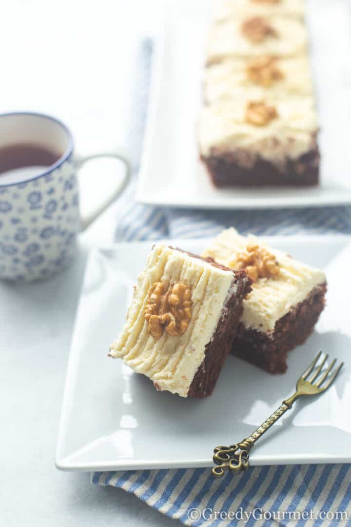 slices of chocolate courgette cake with buttercream icing and a dessert fork.