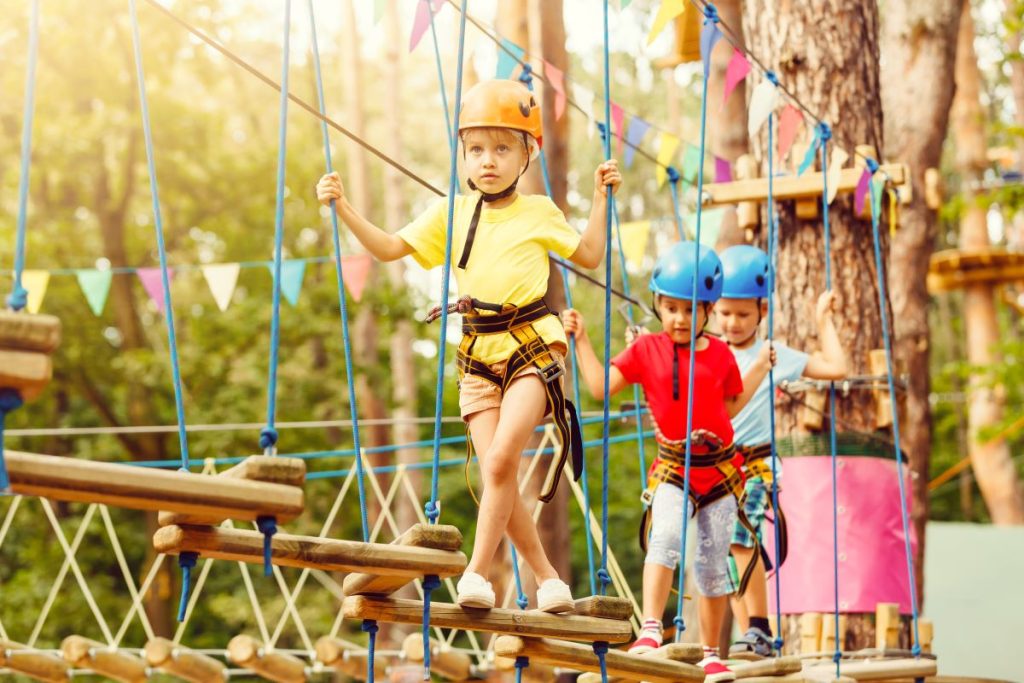 Children walking in a tree climbing trail.