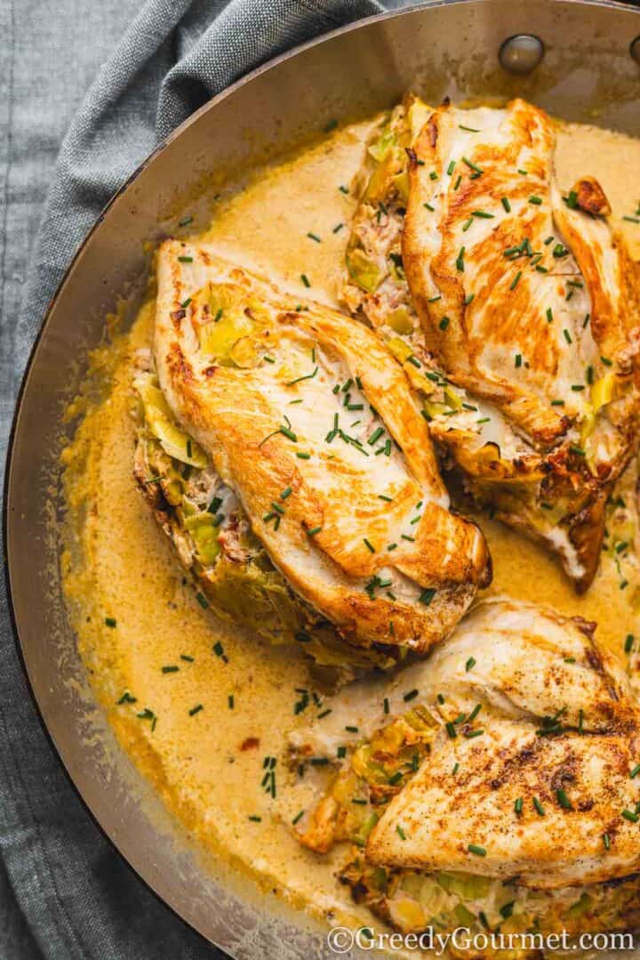 Leek-Stuffed Chicken Breast with a Creamy White Wine Sauce in a pan.