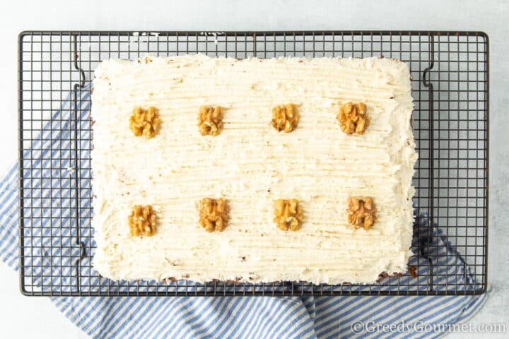 Decorating Chocolate Courgette cake with walnut halves.