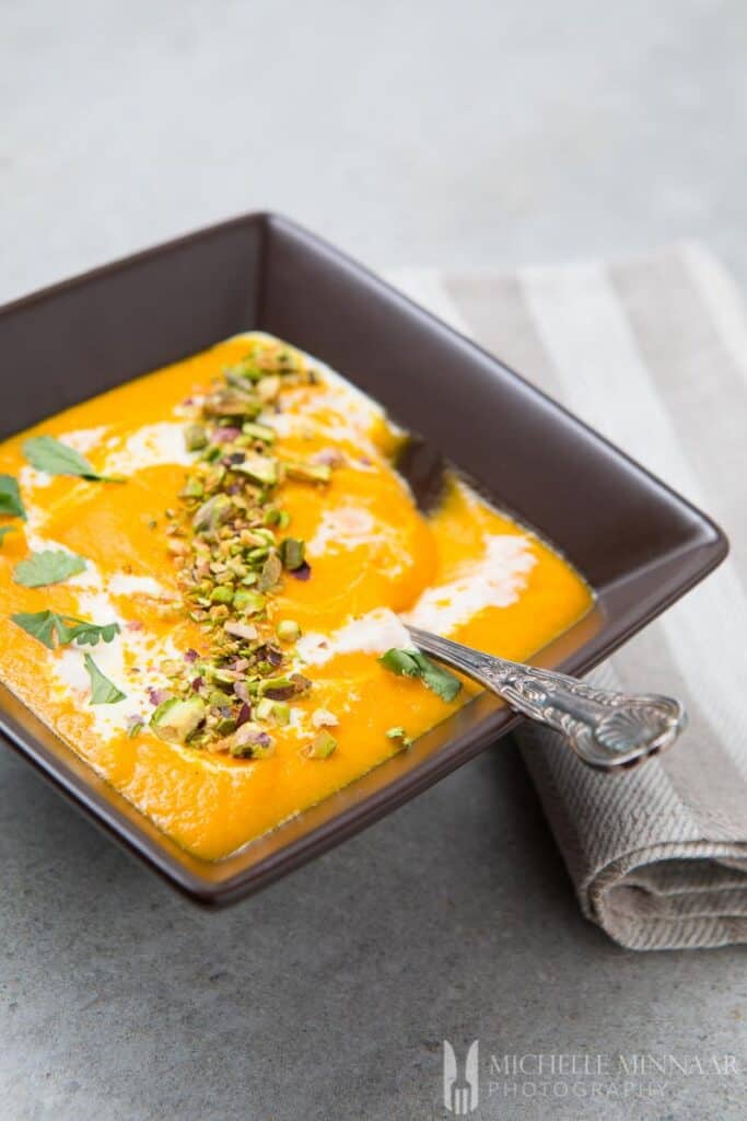 A bowl of orange carrot soup 