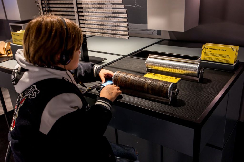 A child solving a puzzle at the Enigma Cipher Centre.