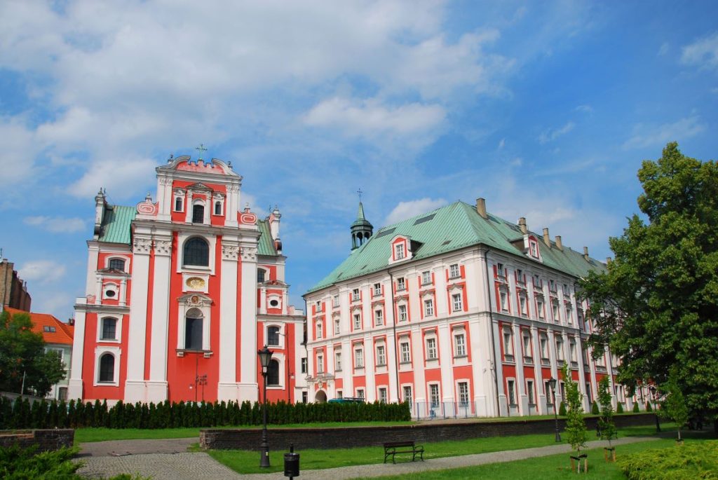 A vibrant red and white building with a green rooftop, Fara Church.