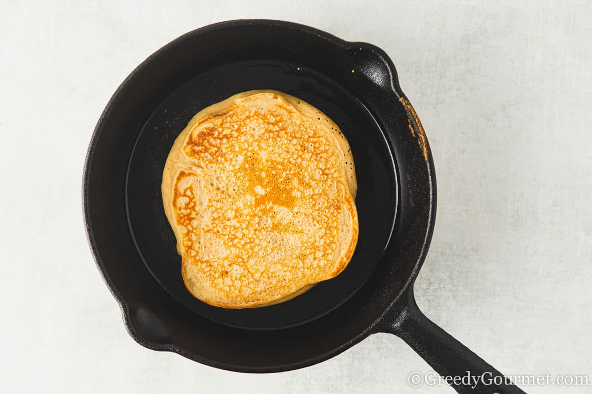 frying biscoff pancakes.