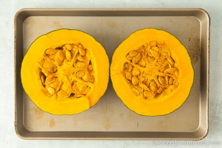 halved kabocha squash on baking tray.