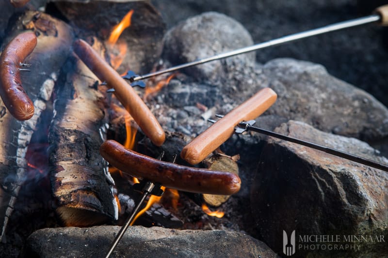 Grilling hotdogs over fire