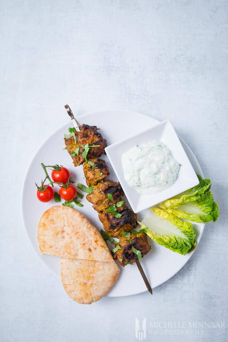 A complete meal of Lamb Tikka, Tomato, Lettuce, Lamb Skewer and yogurt dip