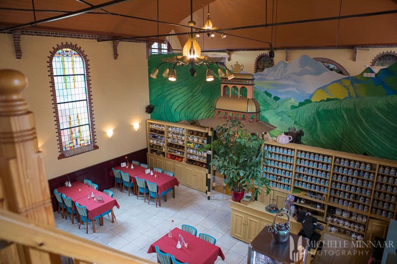 The inside of Fabrique Tea, tables with red table clothes and blue chairs