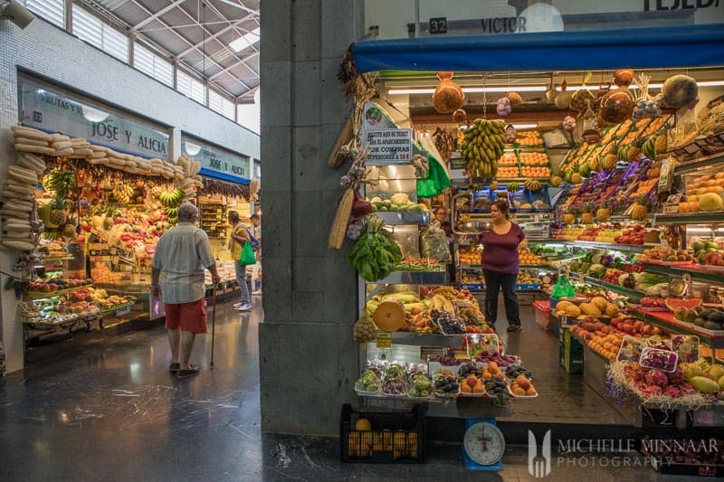 An indoor market with fruit stands