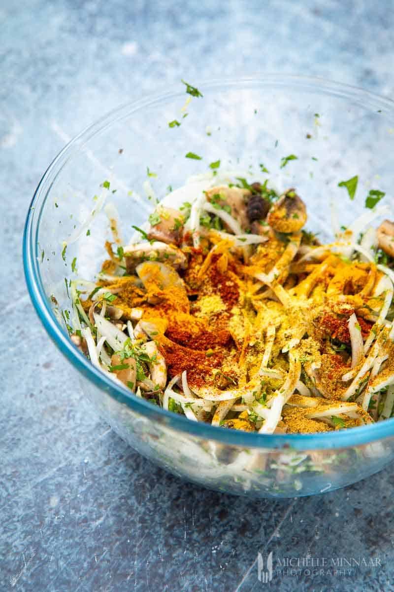 Sliced mushrooms and onions in a bowl 