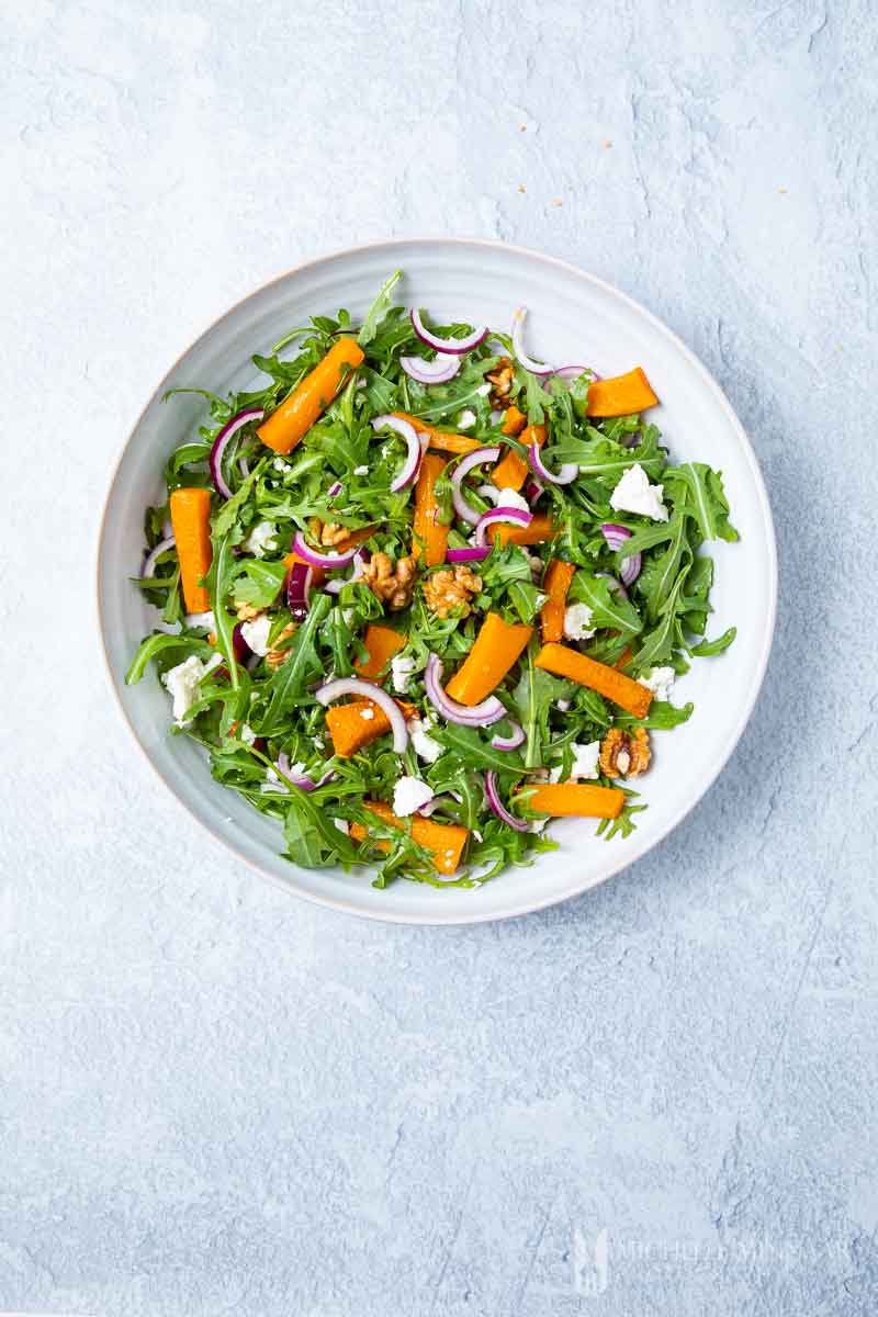 A round plate of pumpkin and feta salad