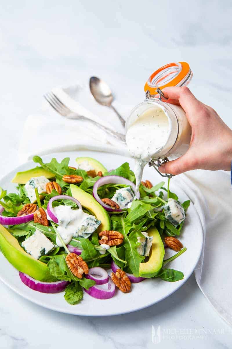 Dressing being poured onto rocket salad