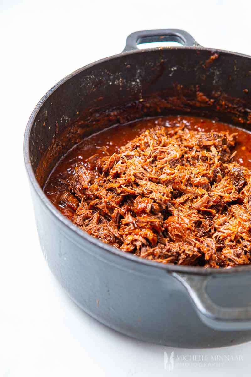 shredded beef in a pot simmering 