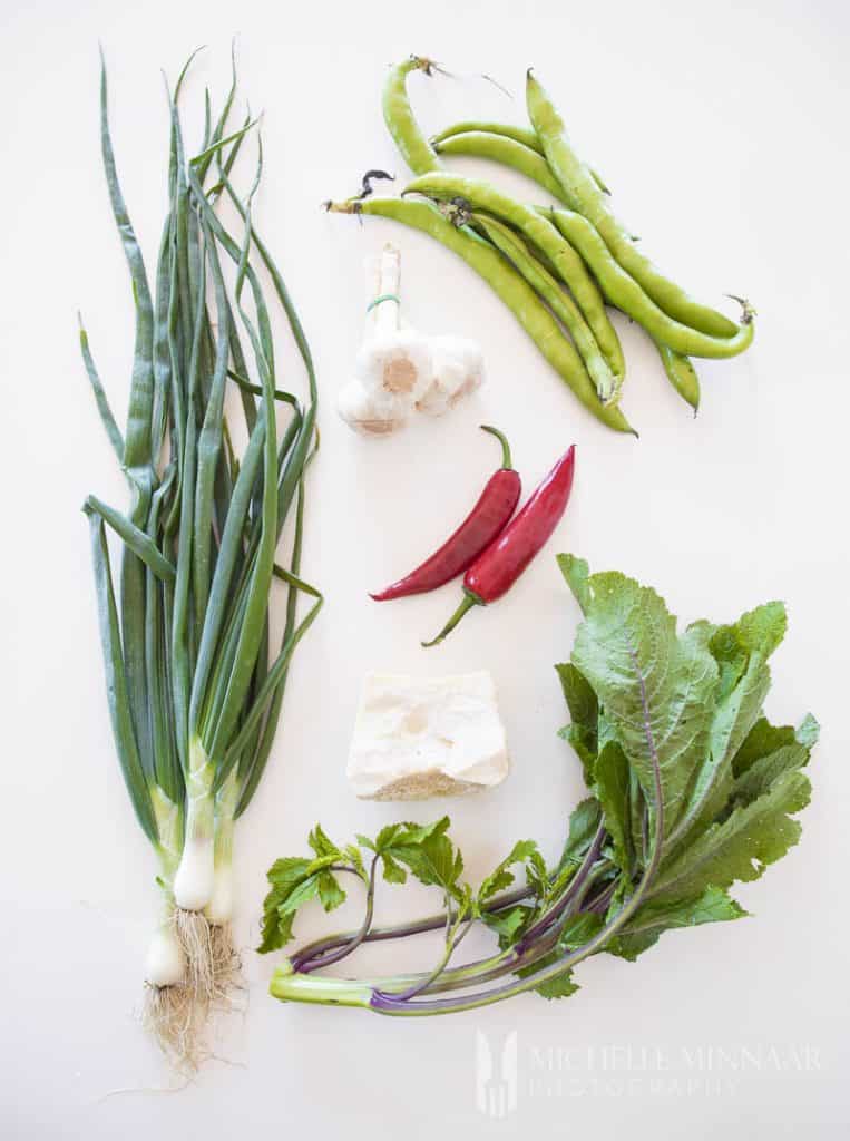 Ingredients to make macco di fave: spring onions, peppers, gralic, green beans 