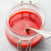 strawberry coulis in a glass jar.