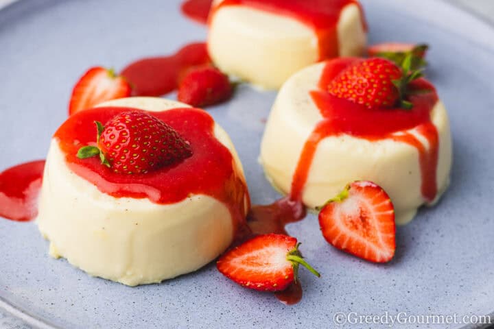 Strawberry coulis on top of ice cream scoops.