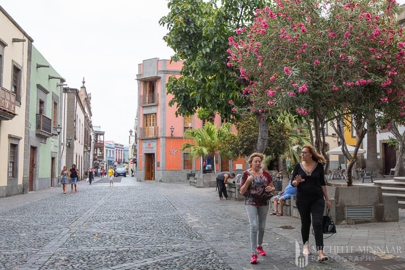 Two woman walking down an alley 