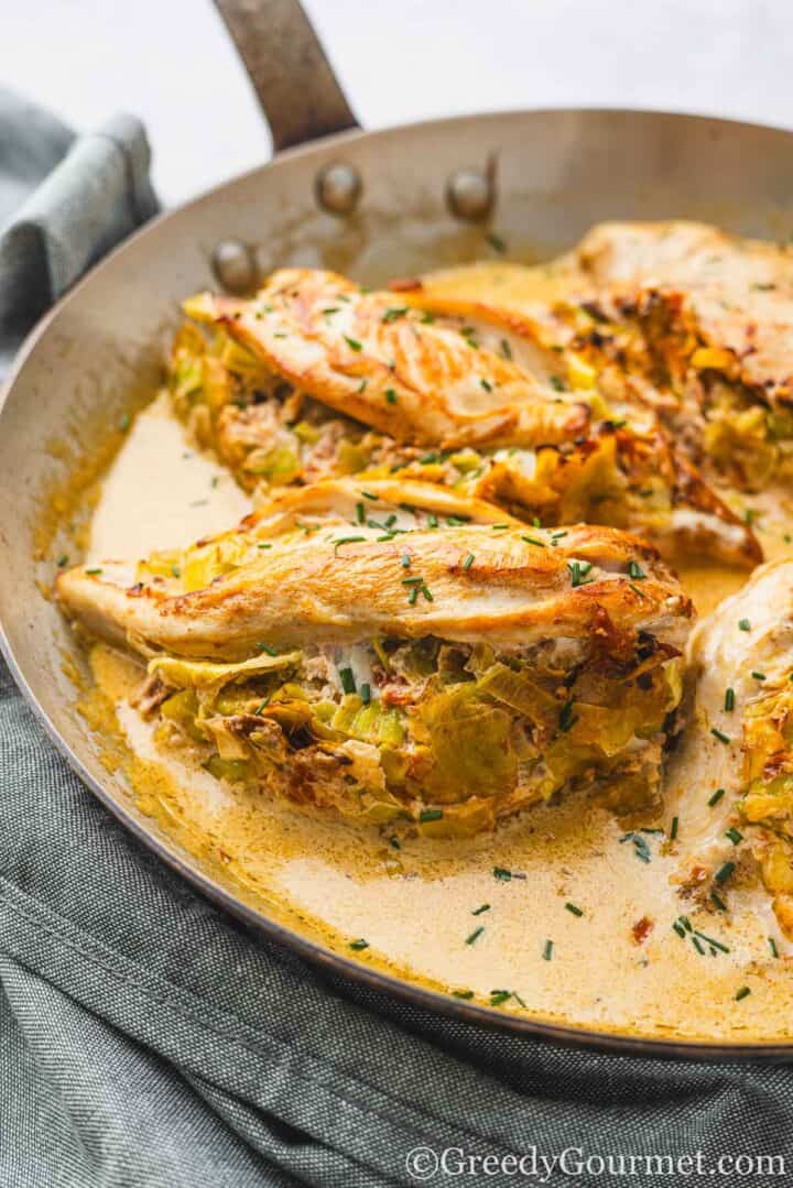 Leek-Stuffed Chicken Breast with a Creamy White Wine Sauce in a pan.