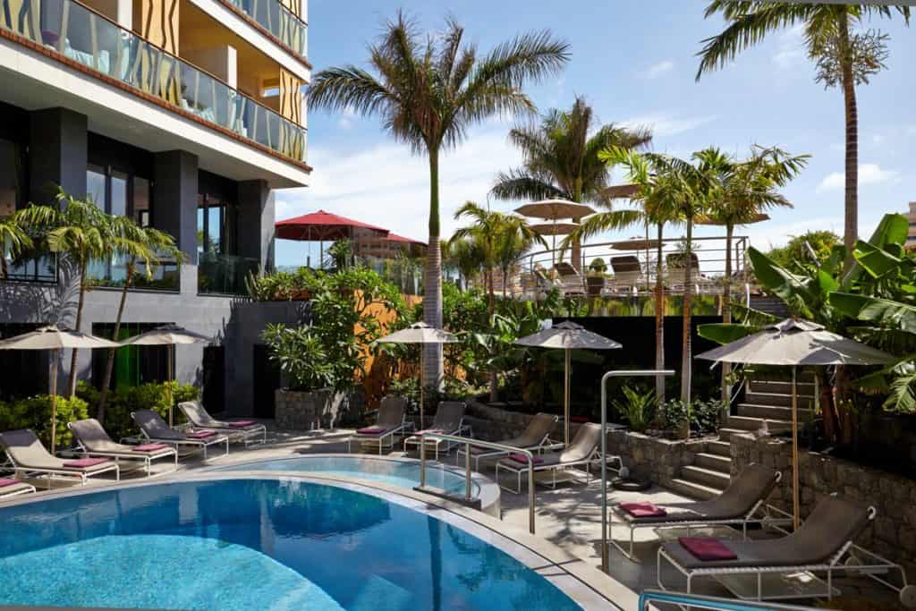 A pool with lounge chairs and palm trees