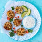 Rounds plate of shrimp fritters and a creamy white dip