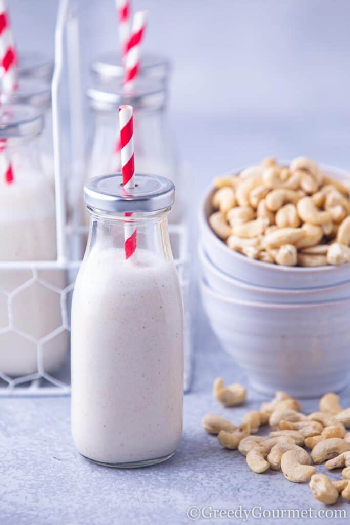 Cashew milk next to a bowl of cashews