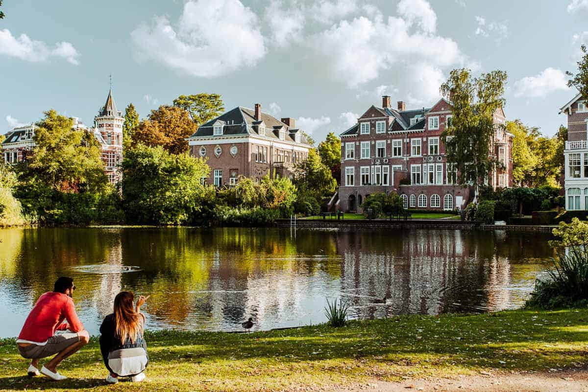 2 people sitting by a lake at Vondelpark.