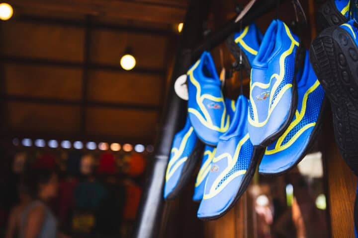 Blue water shoes hanging on shop door. 