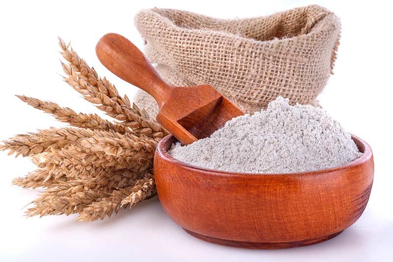 Bowl of whole wheat flour and a wooden spoon